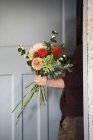 Woman creating a hand tied bouquet. — Stock Photo