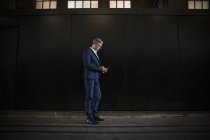 Бізнесмен стоїть в тіні на міській вулиці — стокове фото
