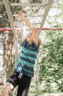 Boy on climbing frame in garden — Stock Photo