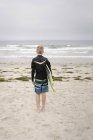 Garçon debout sur la plage de sable — Photo de stock