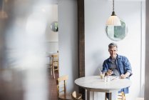 Uomo seduto in caffetteria — Foto stock