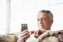 Homme âgé utilisant un téléphone portable . — Photo de stock