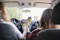 Mujeres en un coche en un viaje por carretera - foto de stock