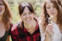 Women holding dandelion closk. — Stock Photo