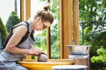 Жінка гончар працює з глиною — стокове фото