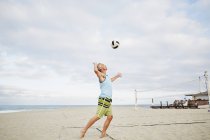 Зрелый мужчина играет в пляжный волейбол . — стоковое фото