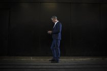 Uomo d'affari in piedi in ombra sulla strada della città — Foto stock