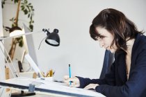 Donna che lavora su un grafico su un tavolo da disegno — Foto stock
