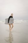 Девушка прогуливаясь по песчаному пляжу — стоковое фото