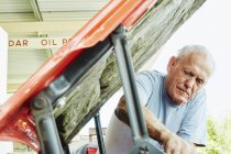 Uomo anziano che ripara un'auto — Foto stock