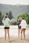 Chicas de pie en la playa de arena - foto de stock
