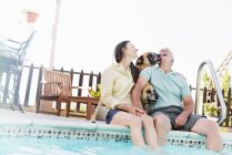 Couple avec chiens à la piscine — Photo de stock