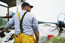 Pescador a bordo de su barco - foto de stock