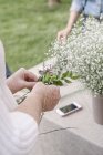 Frau bastelt einen Blumenkranz. — Stockfoto