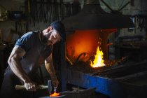 Blacksmith strikes a pieces of hot metal — Stock Photo