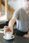 Man standing at a counter in a coffee shop — Stock Photo