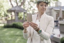 Жінка з квітковим вінком бере селфі — стокове фото