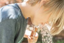 Boy drinking water from garden hose — Stock Photo