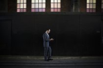 Businessman standing in shadow on city street — Stock Photo