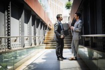 Businessmen standing outdoors and talking — Stock Photo