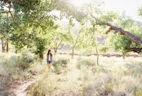 Frau läuft durch Bäume — Stockfoto