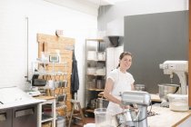 Femme à un comptoir de travail dans une boulangerie . — Photo de stock