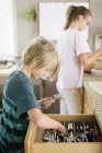 Boy getting cutlery from drawer — Stock Photo