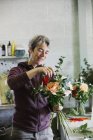 Woman creating a hand tied bouquet. — Stock Photo