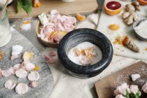 Pestle and mortar and petals, ginger and oranges — Stock Photo