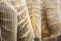 Air dried meat wrapped in nets — Stock Photo