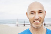 Лысый взрослый мужчина стоит на пляже — стоковое фото