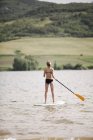 Девушка встает на подножку серфинга — стоковое фото