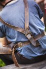 Leather straps of a man's metalworking apron. — Stock Photo