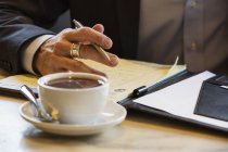 Бизнесмен сидит в кафе с документами — стоковое фото