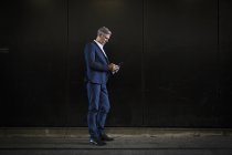 Бизнесмен, стоящий в тени на городской улице — стоковое фото