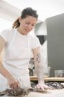 Женщина режет шоколад в пекарне — стоковое фото