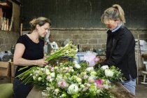 Women at workbench creating floral decorations — Stock Photo