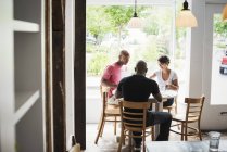 Hommes et femmes déjeunant au café — Photo de stock