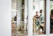 Personnes assises à des tables dans un café — Photo de stock