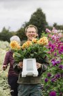 Personas que trabajan en un vivero orgánico de flores - foto de stock