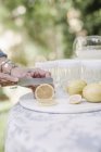 Woman slicing lemons for a drink. — Stock Photo