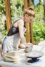 Женщина гончар работает с глиной — стоковое фото