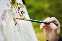 Artista aplicando pintura sobre papel con pincel - foto de stock