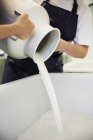 Goats milk being poured from churn — Stock Photo