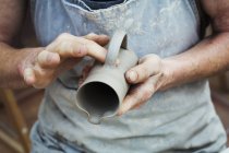 Potter handling a wet clay pot — Stock Photo