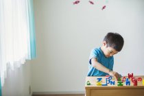 Хлопчик грає з літерами по алфавіту . — стокове фото