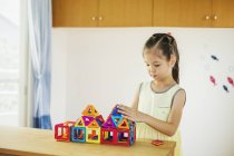 Girl building a structure with geometric shapes. — Stock Photo