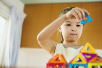 Girl building a structure with geometric shapes. — Stock Photo