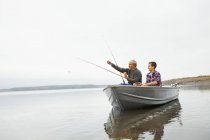 Чоловік і хлопчик риболовля з човна . — стокове фото