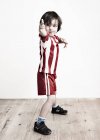 Junge in gestreiftem Hemd und Fußballhose — Stockfoto
